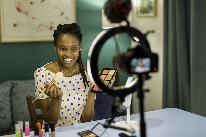 Young Black woman filming a beauty and makeup vlog